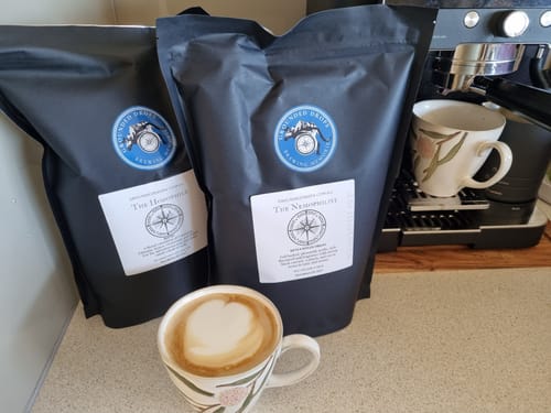 Grounded Drops Nemophilist pouches beside a home espresso machine and a flat white