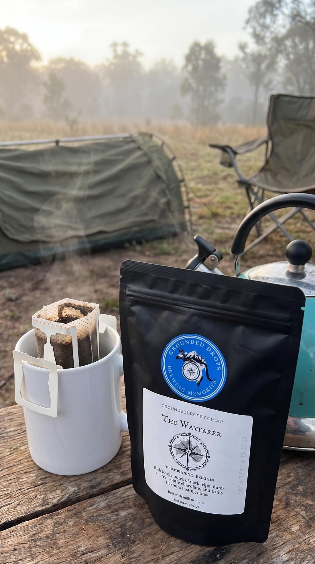 Grounded Drops Wayfarer drip coffee bag brewing on a mug at a misty bush campsite with a swag and camp chair at first light
